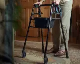 Osoba z chodzikiem, po endoprotezie stawu biodrowego, zastanawia się, jaki stopień niepełnosprawności jej przysługuje.