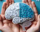 Dłonie trzymają mózg z puzzli, symbolizujący powrót do zdrowia po udarze dzięki fizjoterapii.