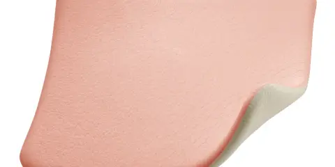 Miękki, różowy plaster na odleżyny na kości ogonowej, zapewniający komfort i ochronę.