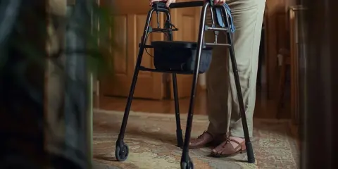 Osoba z chodzikiem, po endoprotezie stawu biodrowego, zastanawia się, jaki stopień niepełnosprawności jej przysługuje.
