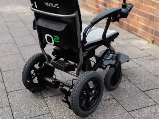 Nowoczesny wózek elektryczny Medilife O2, jeden z wielu rodzajów wózków inwalidzkich, gotowy do jazdy po chodniku.
