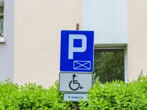 Znak parkingowy dla osób z niepełnosprawnościami, wskazujący 4 miejsca. Informuje o udogodnieniach dla osób z różnymi stopniami niepełnosprawności.
