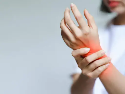 Dłoń z zaczerwienieniem w miejscu bólu, szukamy domowych sposobów na bóle reumatyczne dłoni.