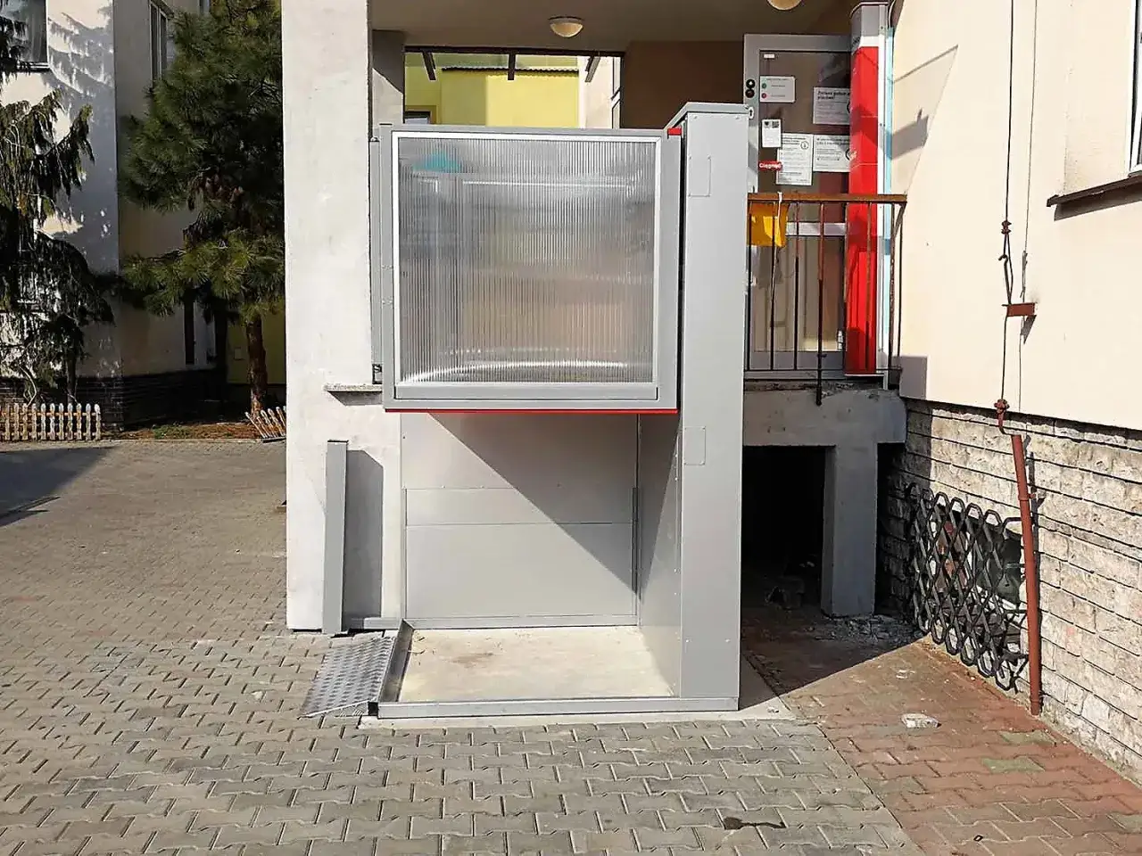 Nowoczesny dźwig dla niepełnosprawnych ułatwia dostęp do budynku.