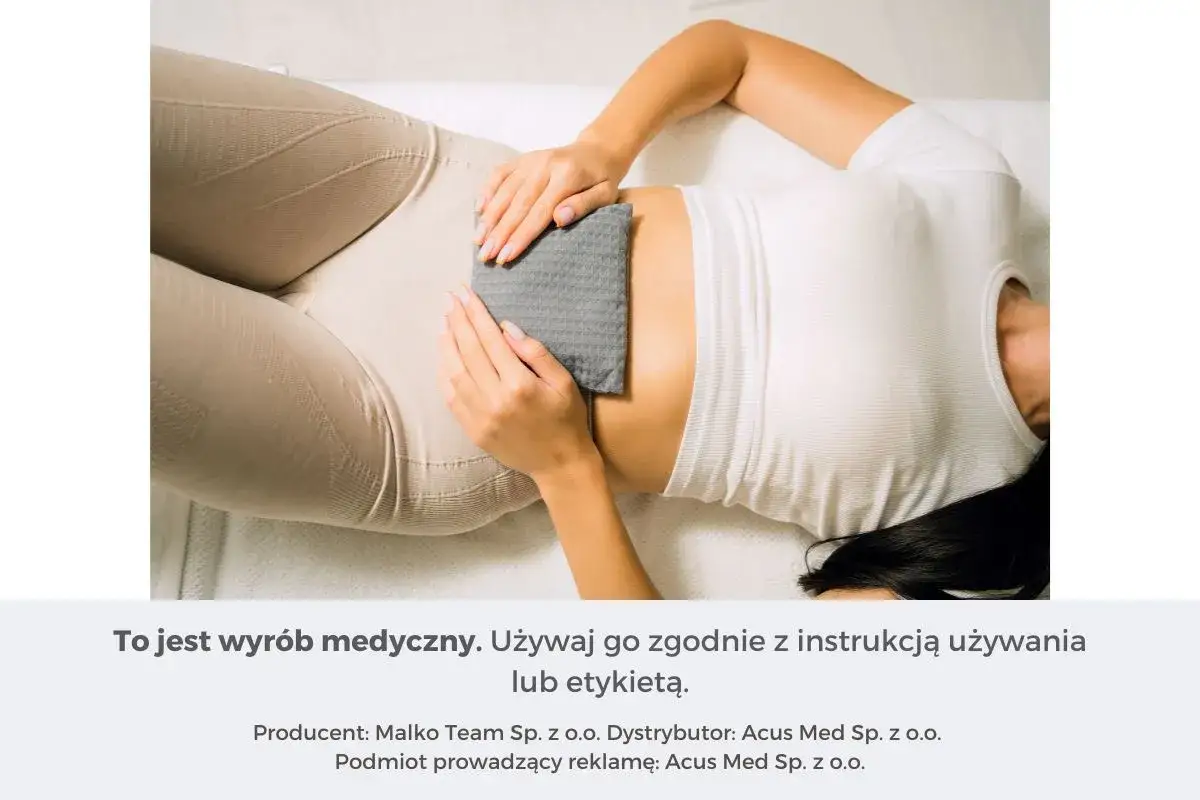 Kobieta z termoforem na brzuchu. Czy do termoforu można wlać wrzątek? Sprawdź instrukcję.
