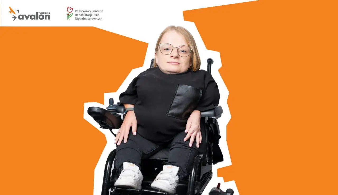 Kobieta w okularach siedzi na w&oacute;zku elektrycznym, wspierana przez Fundację Avalon. Jej niepełnosprawność neurologiczna nie ogranicza jej siły.
