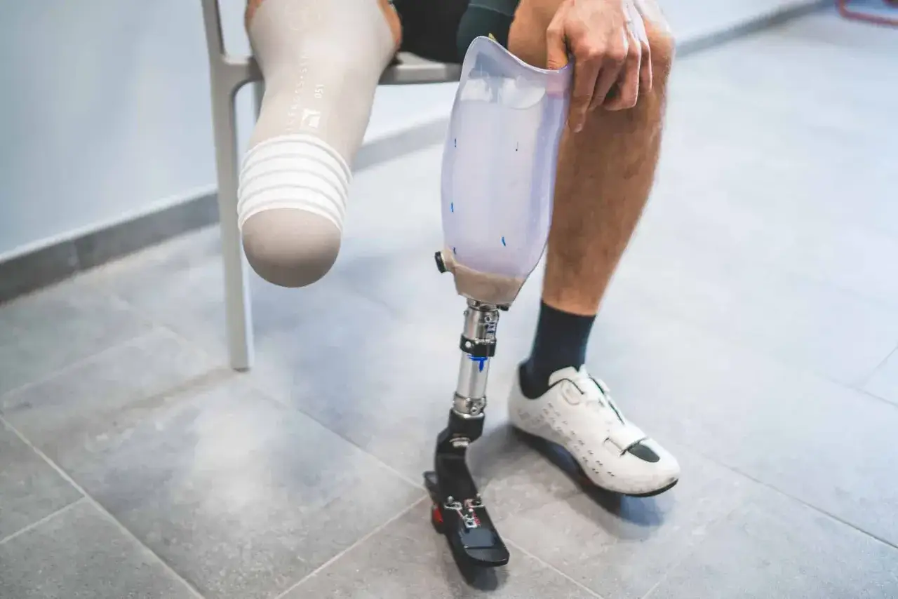 Osoba z protezą nogi, przygotowująca się do ćwiczeń w ośrodkach rehabilitacyjnych po amputacji kończyn.