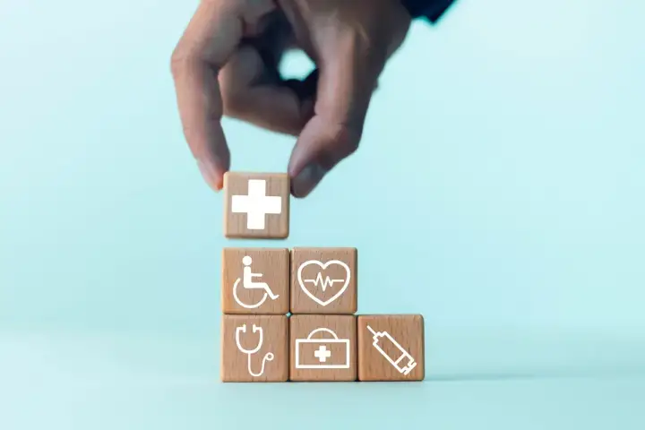 Układanie kostek z symbolami medycznymi: krzyż, wózek inwalidzki, EKG, stetoskop, apteczka, strzykawka. Pokazuje, na jakie choroby można dostać orzeczenie o niepełnosprawności.